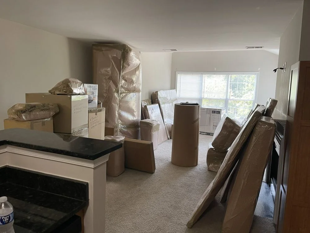 Movers preparing protected household items for loading