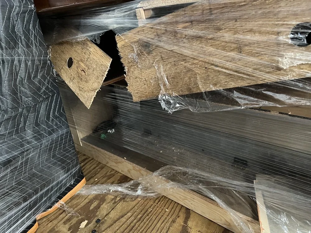Movers preparing protected household items for loading
