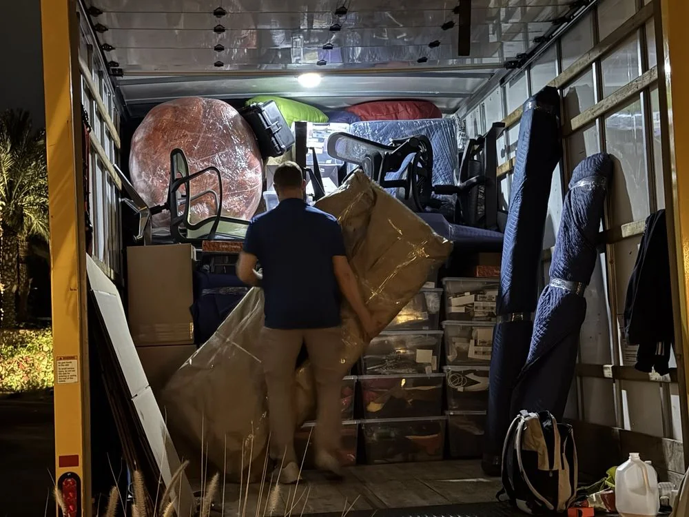 Movers preparing protected household items for loading