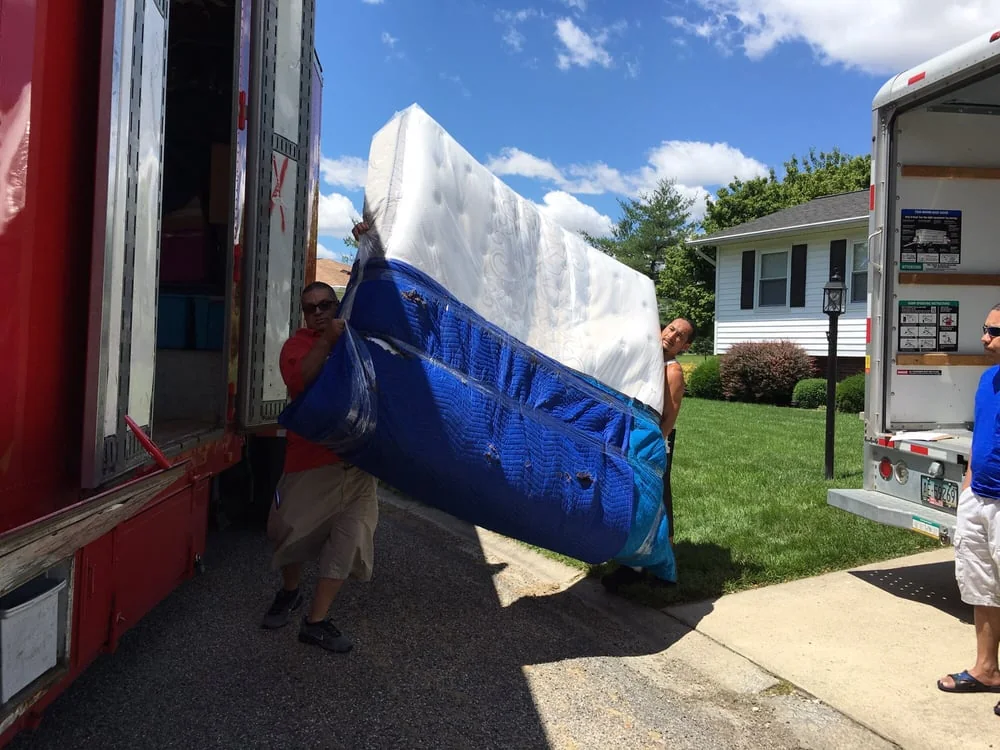 Movers preparing protected household items for loading